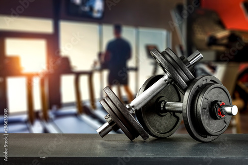 Dumbbell, barbell and workout in the gym. Space for products and decorations or text with blurred gym background.