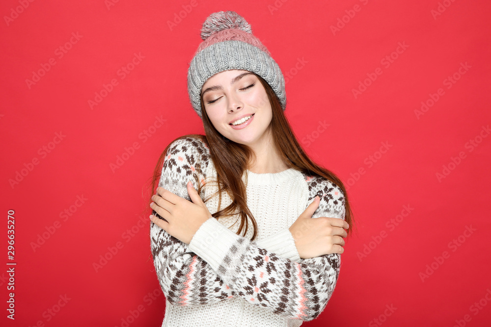 Beautiful woman in sweater and hat on red background Beautiful woman in sweater and hat on red background