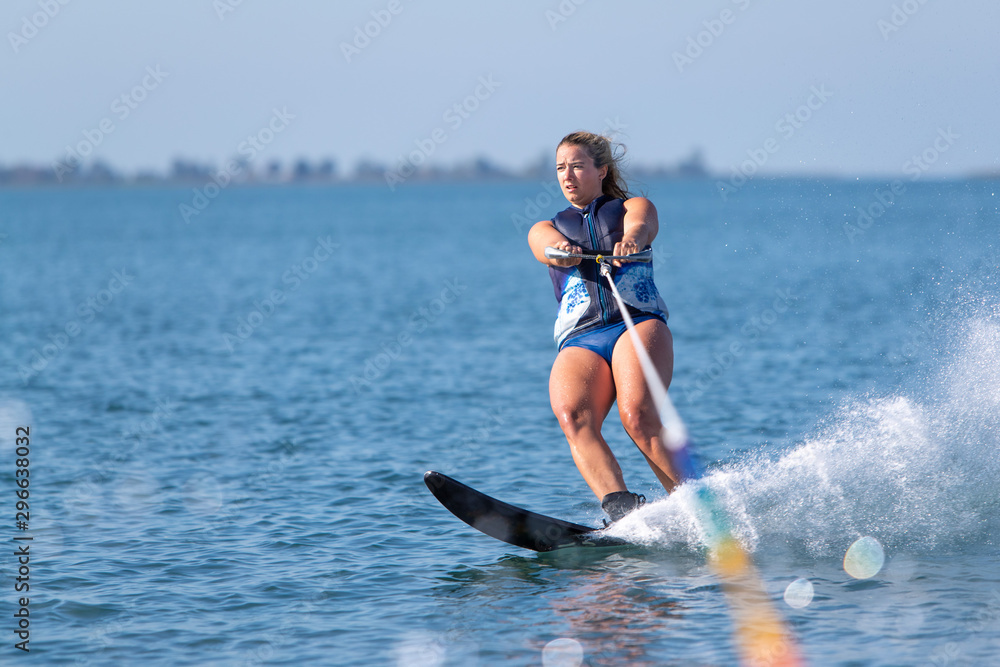 A woman riding a slalom waterski. A woman riding a slalom waterski.