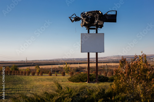 Billboard blank for outdoor advertising poster about dangerous cars crash on road, with smashed car on top.