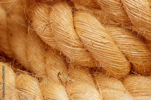 Rough Cord made from natural plant fiber. Rope detail, closeup. Horizontal. Orange tone. Copy space. Wallpaper and background about fabtic manufacture, eco friendly material.