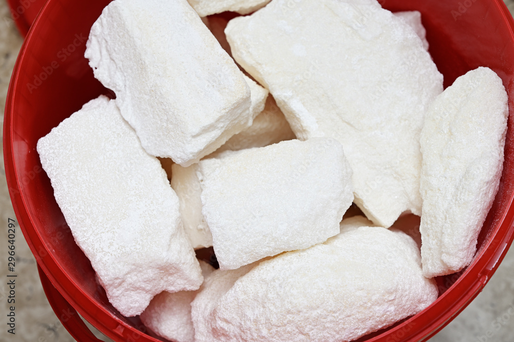 Lumps of sugar in a red plastic bucket. Lumps of sugar in a red plastic bucket.