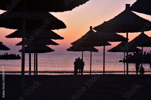 people under umbrellas on the beach in the morning © sebi_2569