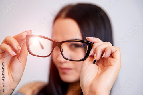 Quadro su tela Portrait of a young woman with spectacles in hands