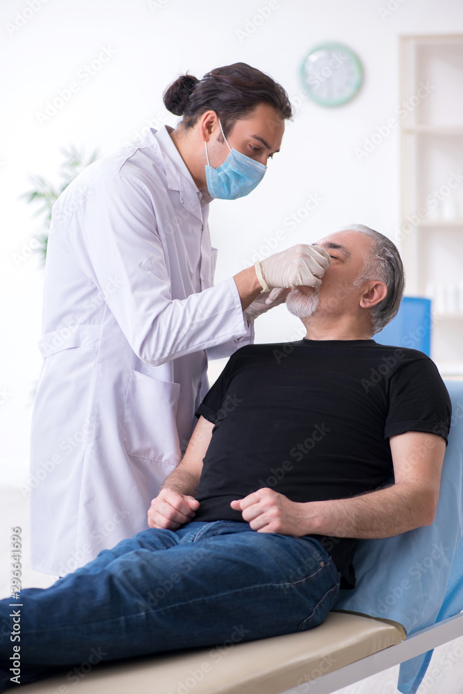 Fototapeta premium Old man visiting young doctor for plastic surgery