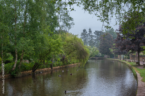 BOURTON-ON-THE-WATER, COTSWOLDS, UK - MAY 28, 2018: Stone footbridge across the River Windrush in Bourton-on-the-Water, also known as The Venice of the Cotswolds - Gloucestershire - England -UK