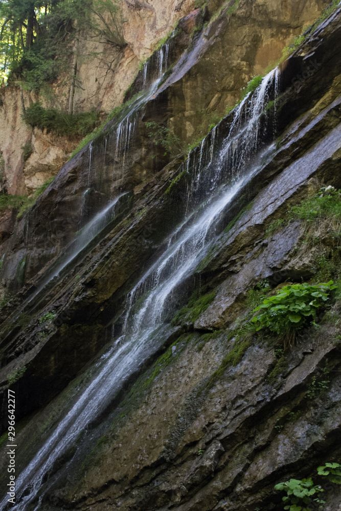 small waterfalls in a small mountain gorge on a spring sunny day. Waterfall Gorge in the Bavarian Alps