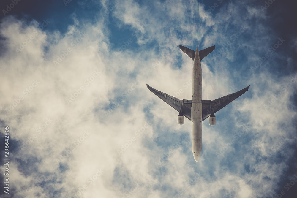 Naklejka premium Airplane on blue sky with clouds. Travel around the world in the air