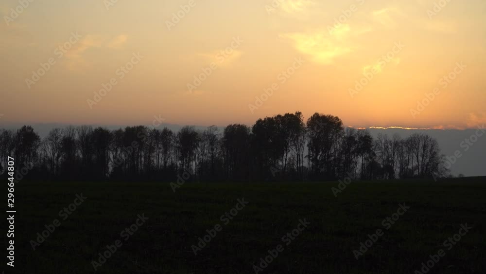 The sunset contrasts in the autumn evening time. Yellow sunlight at the back of clouds and the tree silhouettes. Latvia countryside nature. The sunset contrasts in the autumn evening time. Yellow sunlight at the back of clouds and the tree silhouettes. Latvia countryside nature.