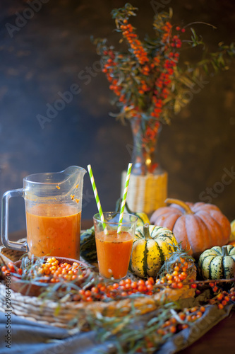 Brown table with common sea buckthorn drink and berreis Homemade sea buck thorn liqueur, Hippophae rhamnoides, on the wooden board.  Brown tabl sea buckthorn pumpkin smoothie, fresh vegan autumn drink photo