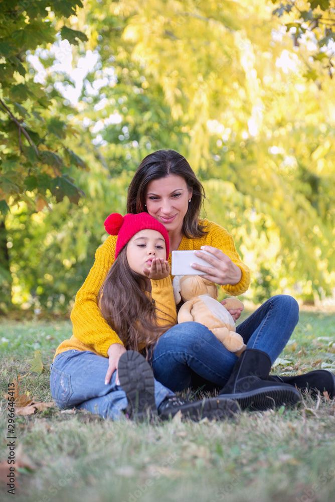 Mother and daughter taking Selfie in the park Mother and daughter taking Selfie in the park