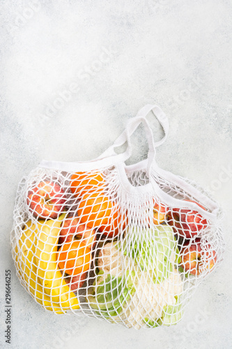 Zero waste shopping concept, fruits vegetables in white net bag on white background