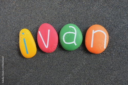 Ivan, masculine given name composed with multicolored stones over black volcanic sand photo