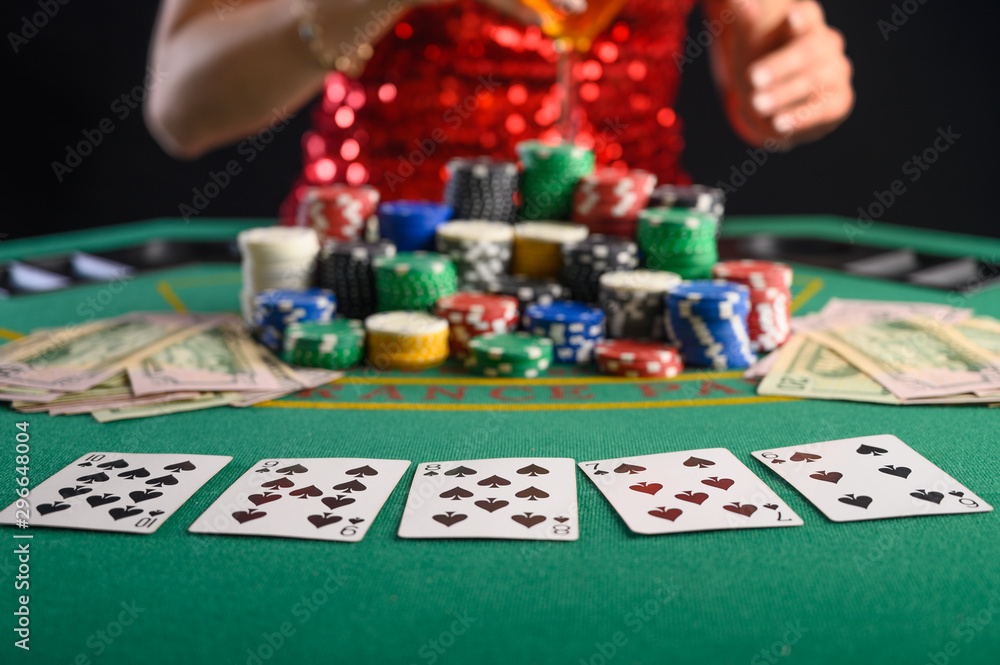 Fototapeta premium Girl plays cards in a casino, a lot of chips, cards, video. Success and win. Poker
