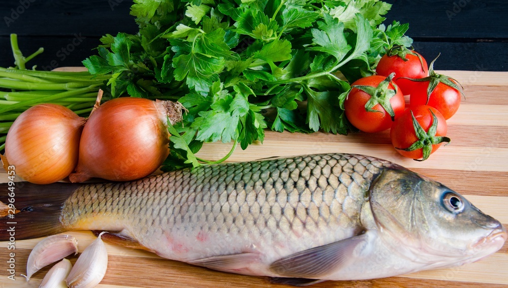 Uncooked fish on cutting board in meal preparation concept Uncooked fish on cutting board in meal preparation concept