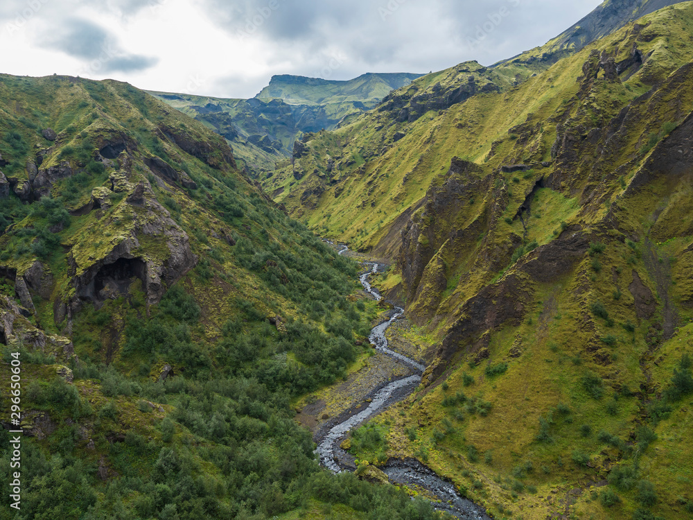 Landscape of Godland and thorsmork with rugged green moss covered rocks and hills, bending river canyon, Iceland, Fimmvorduhals hiking trail. Summer cloudy day.