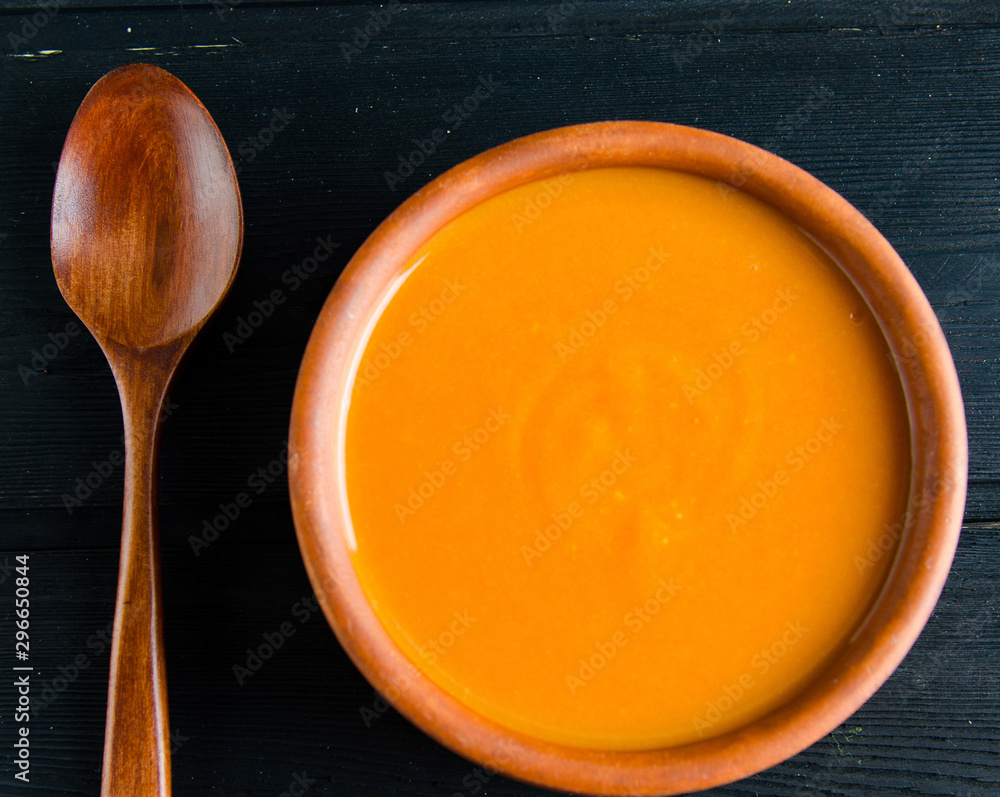 Carrot soup served on the table in bowl Carrot soup served on the table in bowl