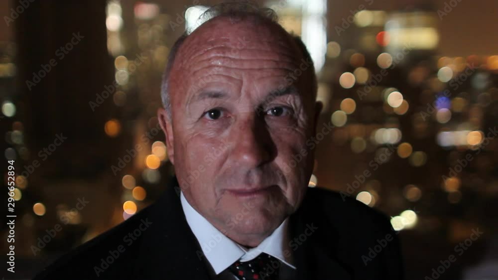 Portrait of a confident mature businessman with manhattan skyline at night Portrait of a confident mature businessman with manhattan skyline at night