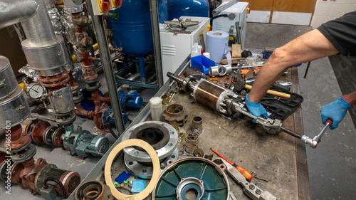 Mechanical engineer removing bearings from an armature