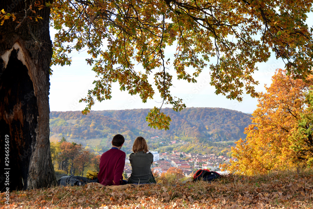Couple sitting on a hill overlooking the old city, Romania Couple sitting on a hill overlooking the old city, Romania
