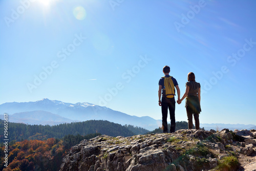 A couple on top of a mountain looks into the distance, Romania © Natalia