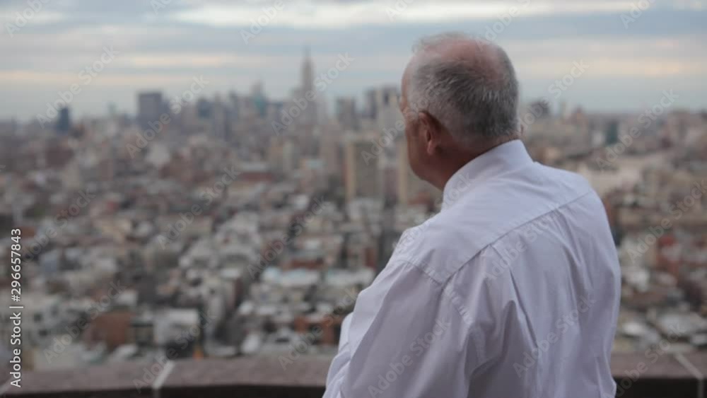 Mature businessman talking on mobile phone with Manhattan in the background Mature businessman talking on mobile phone with Manhattan in the background