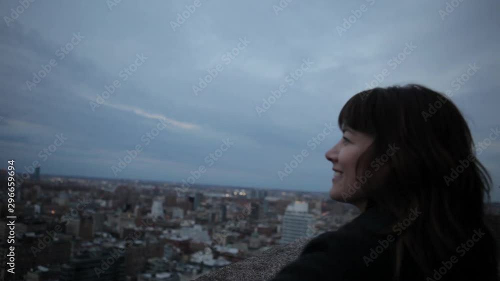 Smiling and happy attractive young woman standing on building overlooking New York City Skyline Smiling and happy attractive young woman standing on building overlooking New York City Skyline