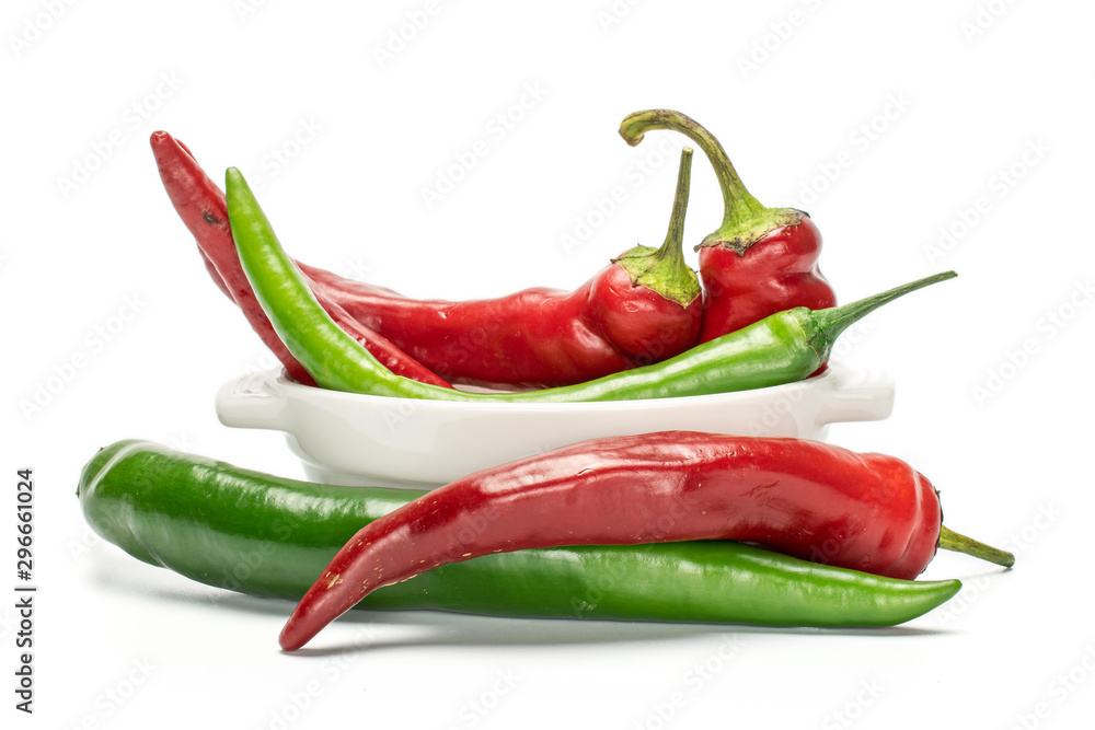 Group of five whole fresh hot pepper in ceramic stewpan isolated on white background