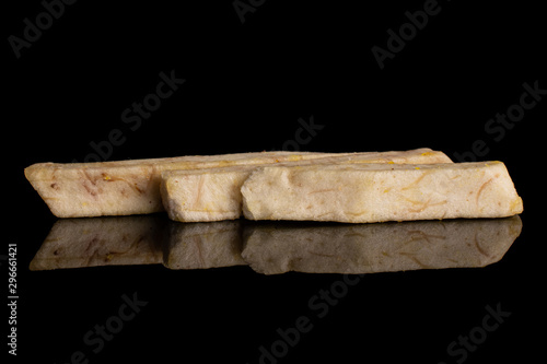 Group of three whole dry vegetable chip of taro isolated on black glass