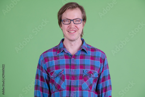 Face of happy young handsome hipster man with eyeglasses smiling © Ranta Images