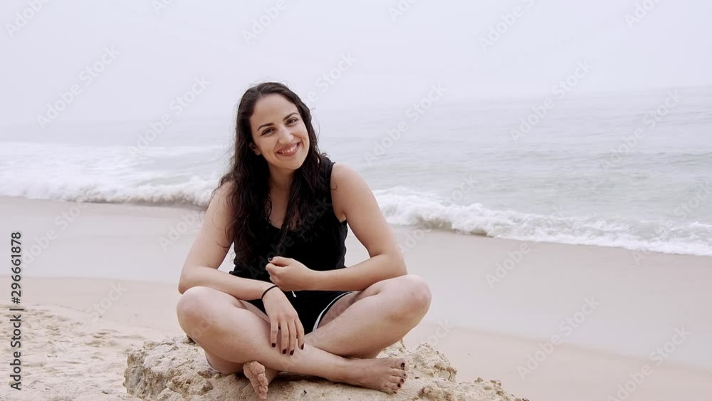 Young woman relaxes on the beach during her summer vacation - slow motion shot Young woman relaxes on the beach during her summer vacation - slow motion shot