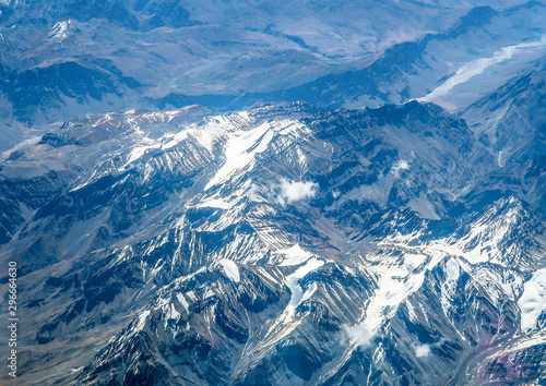 Aerial view from the airplane, clouds and snow over the mountains © grafixme