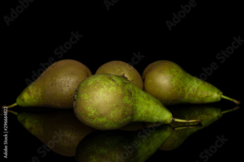 Group of four whole fresh green pear isolated on black glass photo