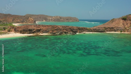 The white sand beach of Tanjung Aan in Lombok, Indonesia during a sunny day. Aerial shot. photo