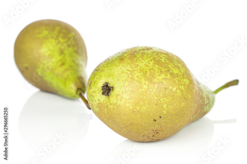 Group of two whole fresh green pear front focus isolated on white background