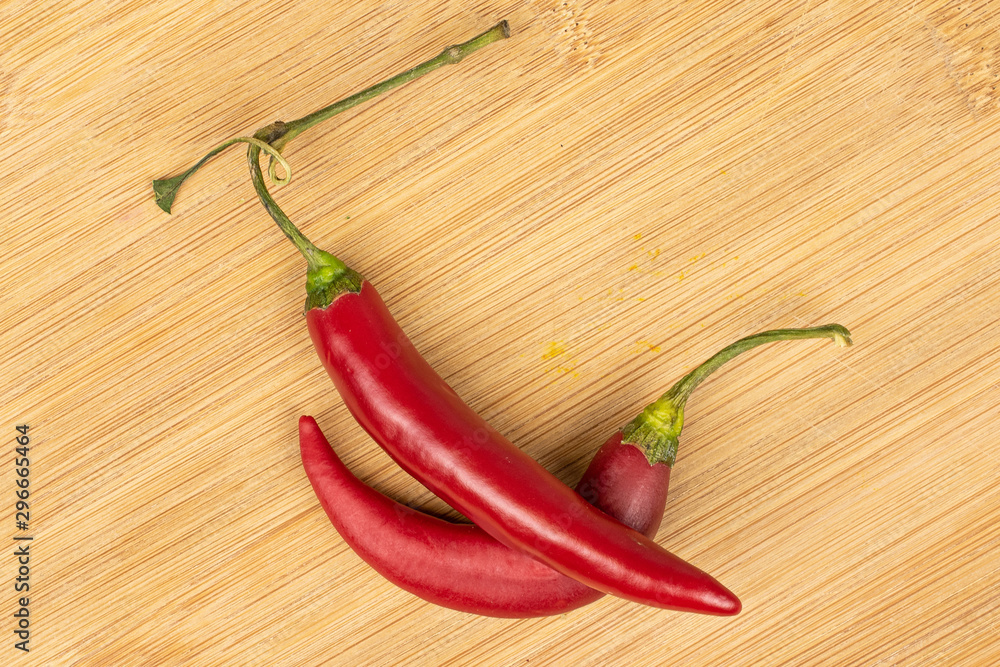 Group of two whole hot red chili cayenne flatlay on light wood