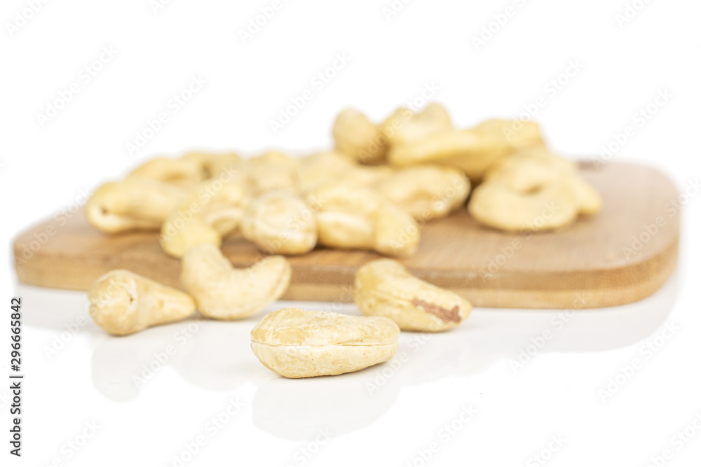 Lot of whole brown nut cashew on bamboo cutting board isolated on white background Lot of whole brown nut cashew on bamboo cutting board isolated on white background