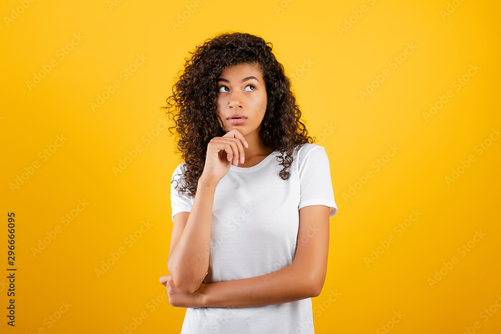 young black woman thinking isolated over yellow