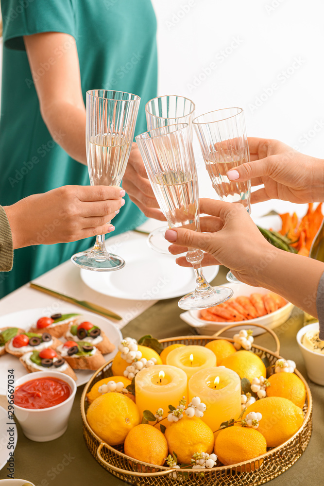 Friends clinking glasses with champagne during dinner, closeup Friends clinking glasses with champagne during dinner, closeup
