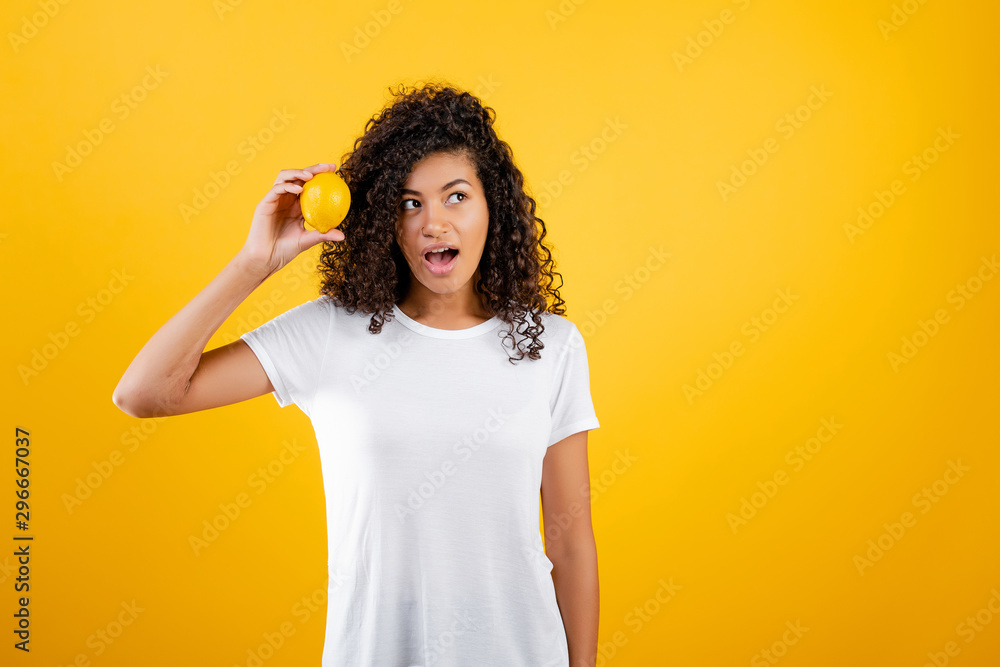 healthy young african black girl with lemon isolated over yellow healthy young african black girl with lemon isolated over yellow