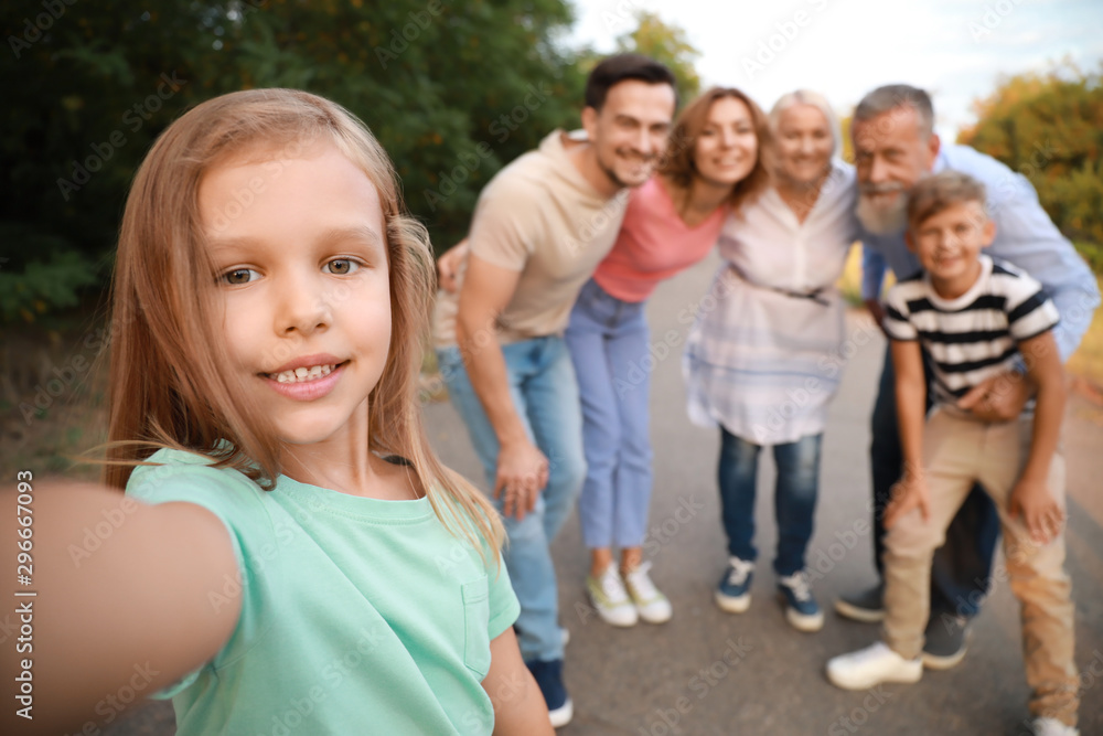 Little girl with her family taking photo outdoors Little girl with her family taking photo outdoors