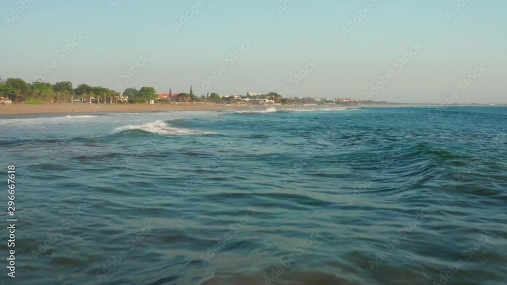 The beaches of Canggu during sunset. With beach clubs, hotels, resorts, restaurants and surfers. Aerial shot.