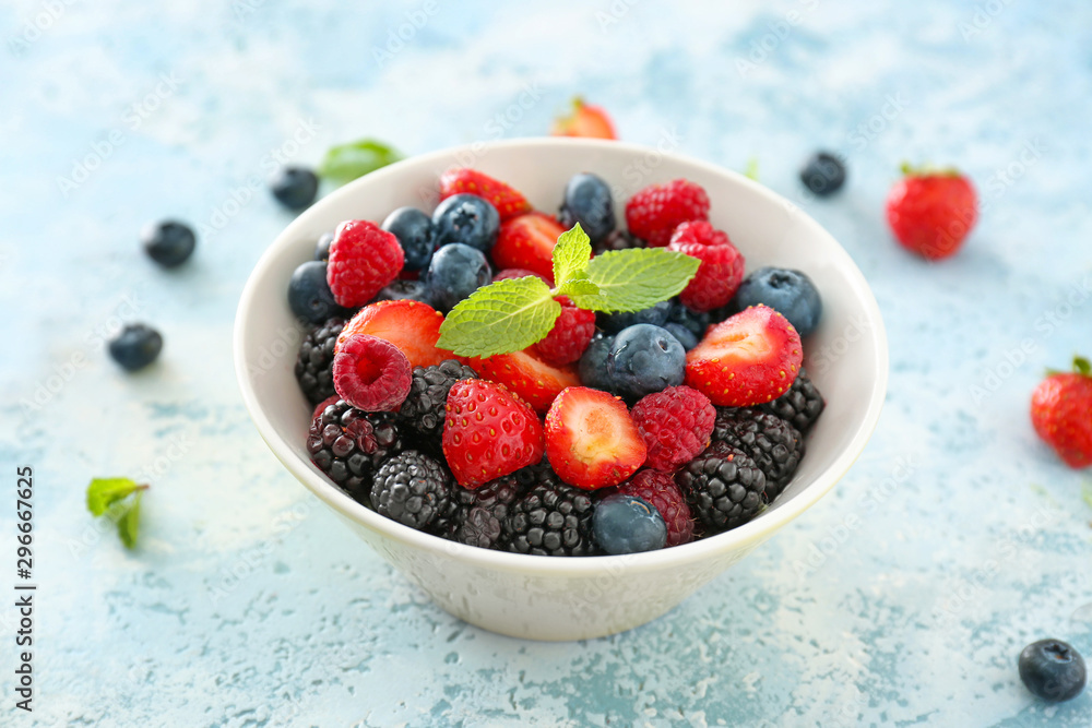 Bowl with tasty berry salad on color background Bowl with tasty berry salad on color background