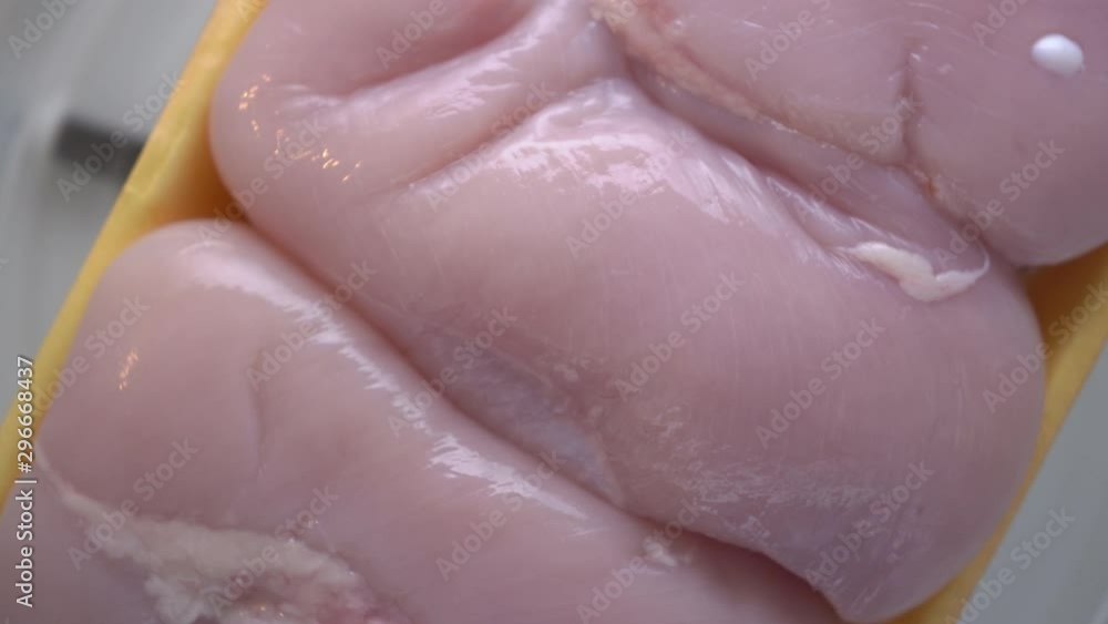 Fresh raw chicken breast fillets in food tray rotating in microwave top view. Fresh raw chicken breast fillets in food tray rotating in microwave top view.
