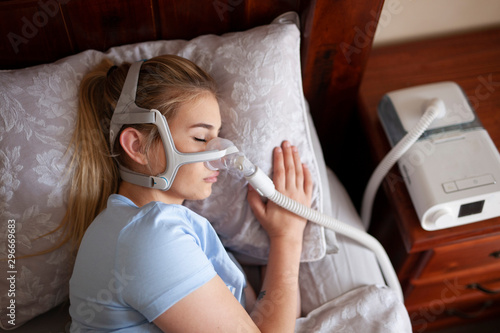 Young female sleeping with cpap machine for sleep apnea © Hope