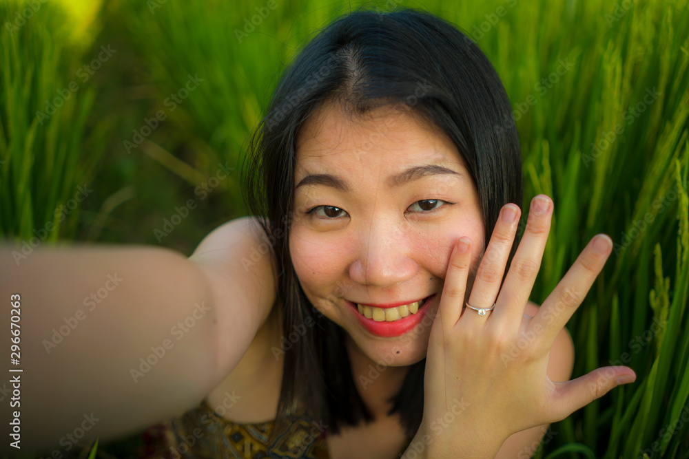 Φωτογραφία young happy and beautiful Asian woman taking selfie photo outdoors showing proud her engagement ring