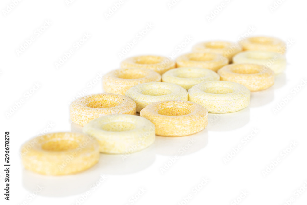 Lot of whole disordered round pale yellow candy isolated on white background