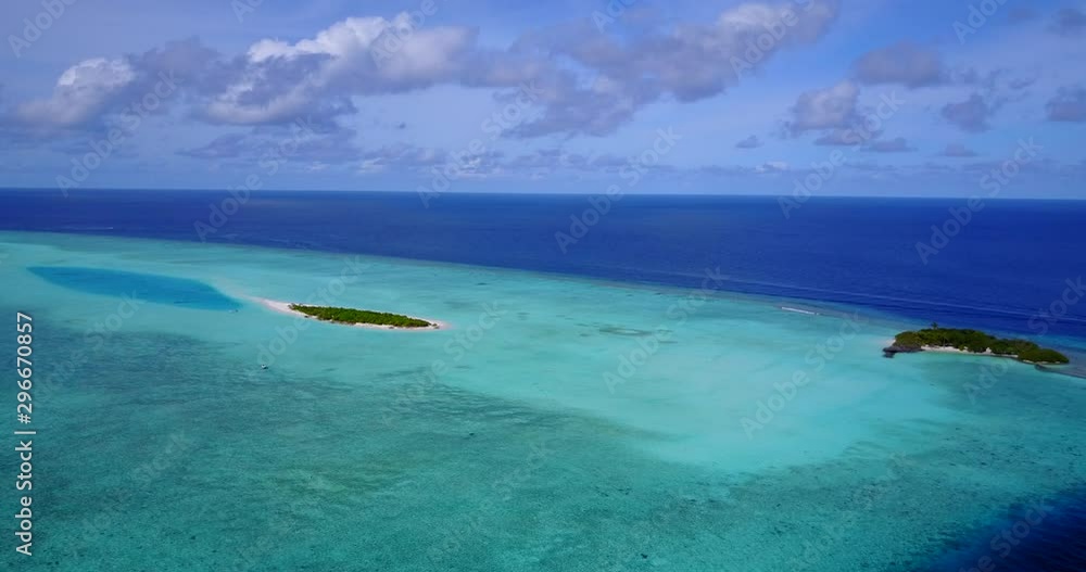 Aerial view looking out towards two small islands on top of a shallow sand bar with deeper water surrounding them in Malaysia Aerial view looking out towards two small islands on top of a shallow sand bar with deeper water surrounding them in Malaysia