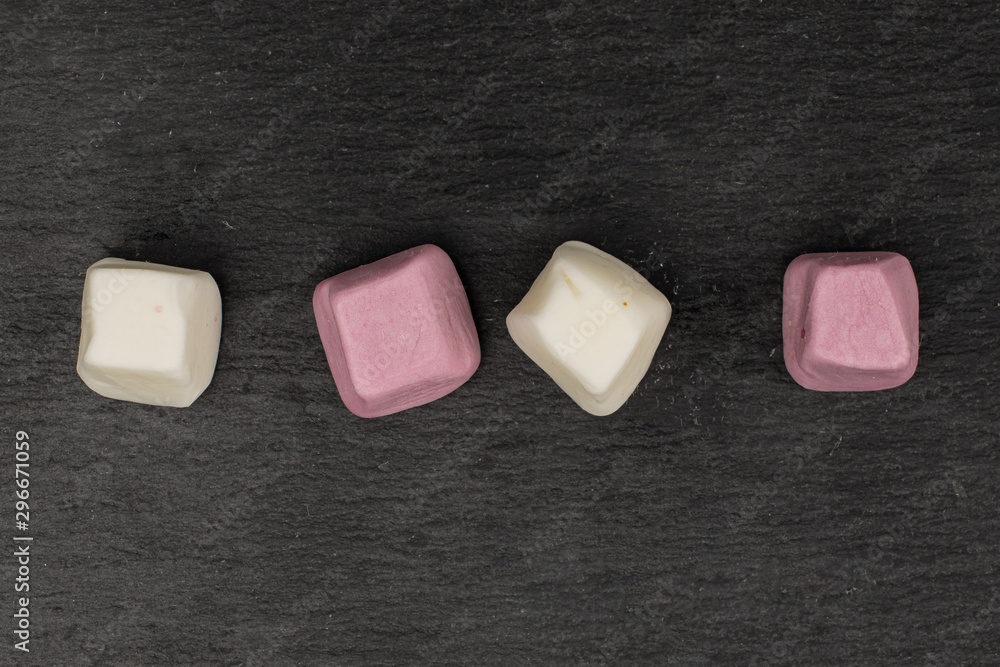 Group of four whole soft pastel candy flatlay on grey stone Group of four whole soft pastel candy flatlay on grey stone