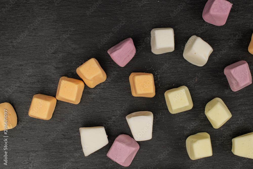 Lot of whole soft pastel candy flatlay on grey stone Lot of whole soft pastel candy flatlay on grey stone